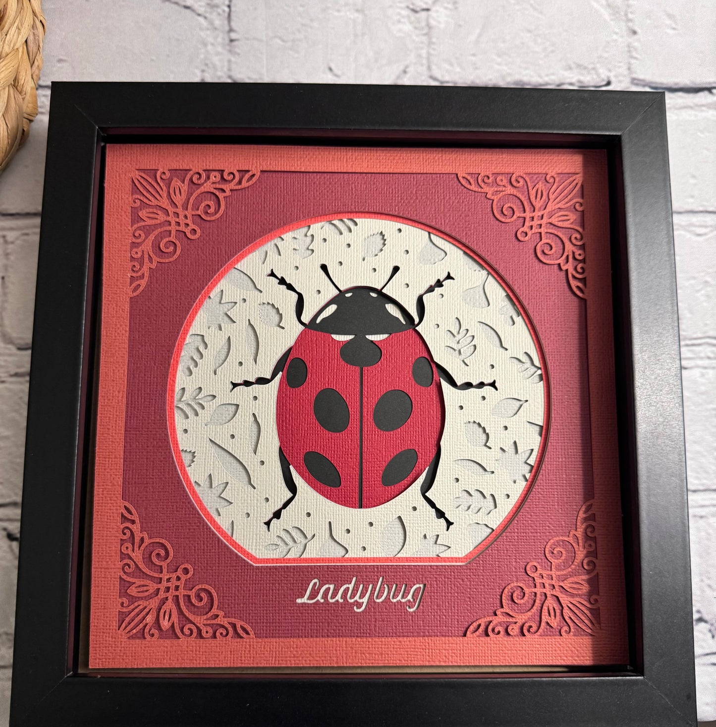 Intricate frame ladybug 3D paper art in a shadowbox