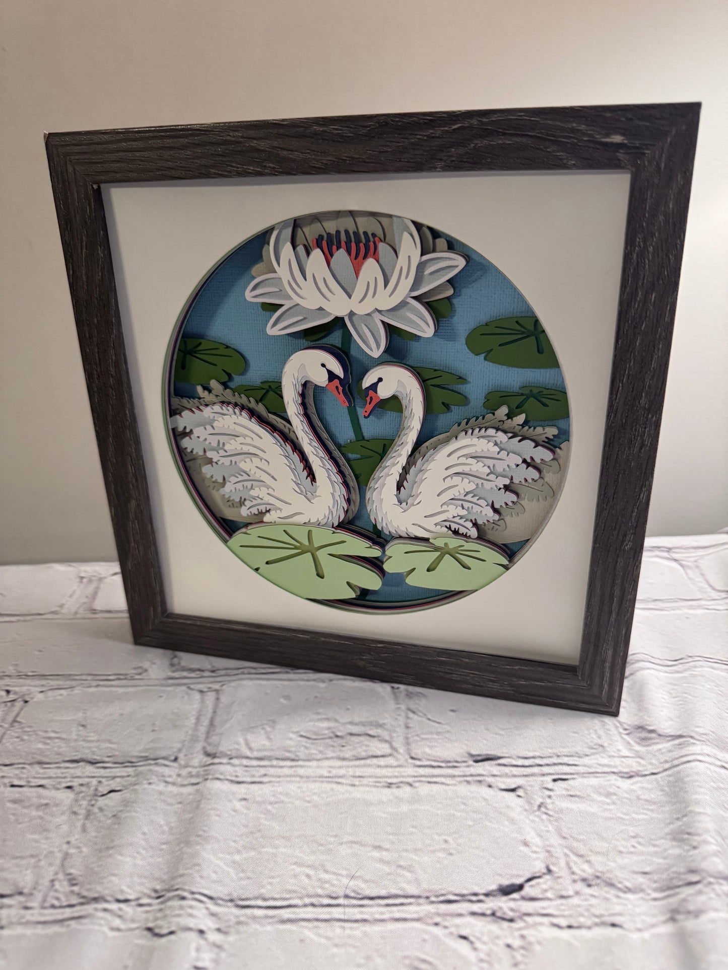 Swans on a lake 3D paper art in a shadowbox