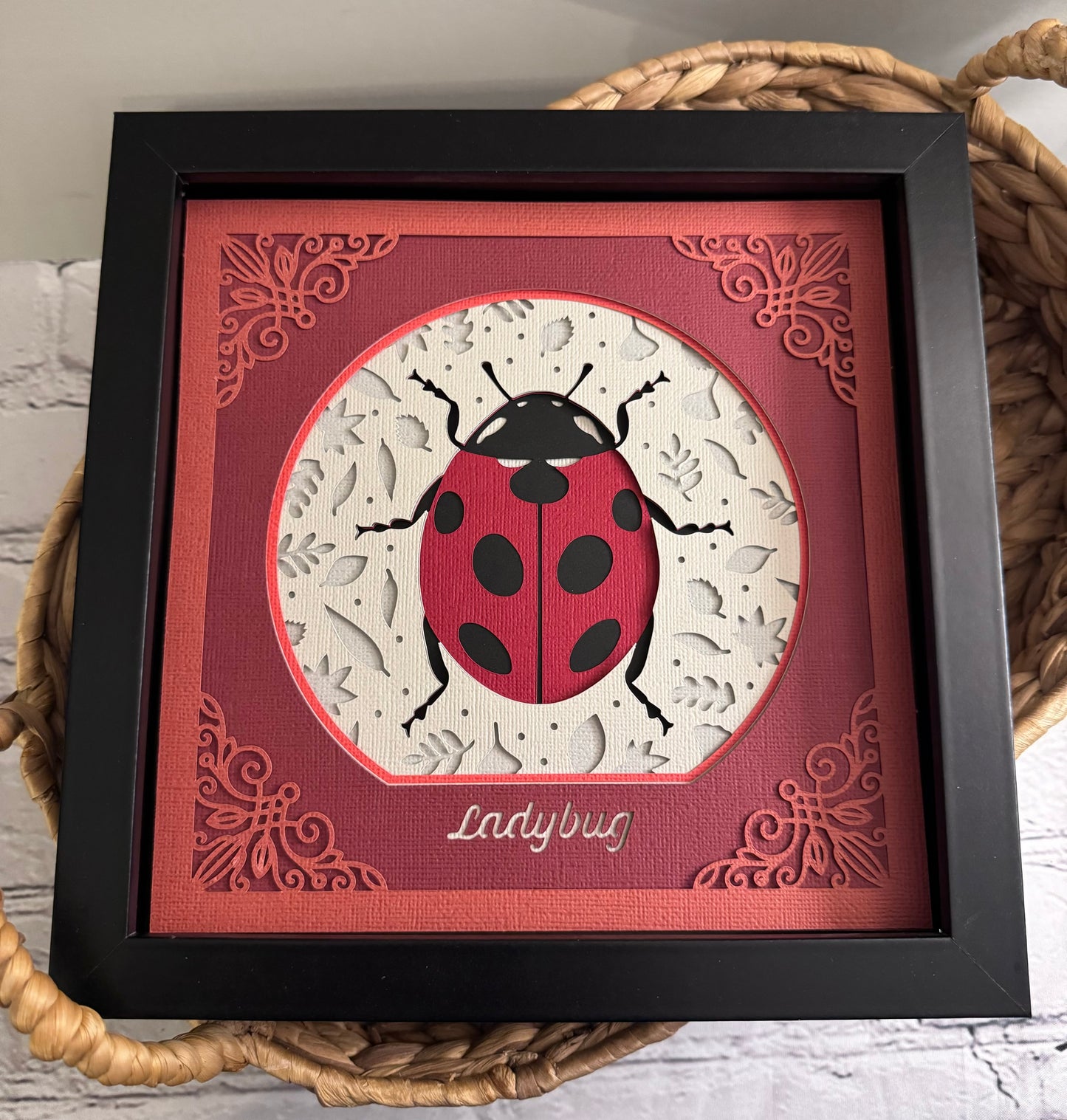 Intricate frame ladybug 3D paper art in a shadowbox