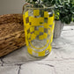 Checkerboard smiley face with star eyes beer can glass